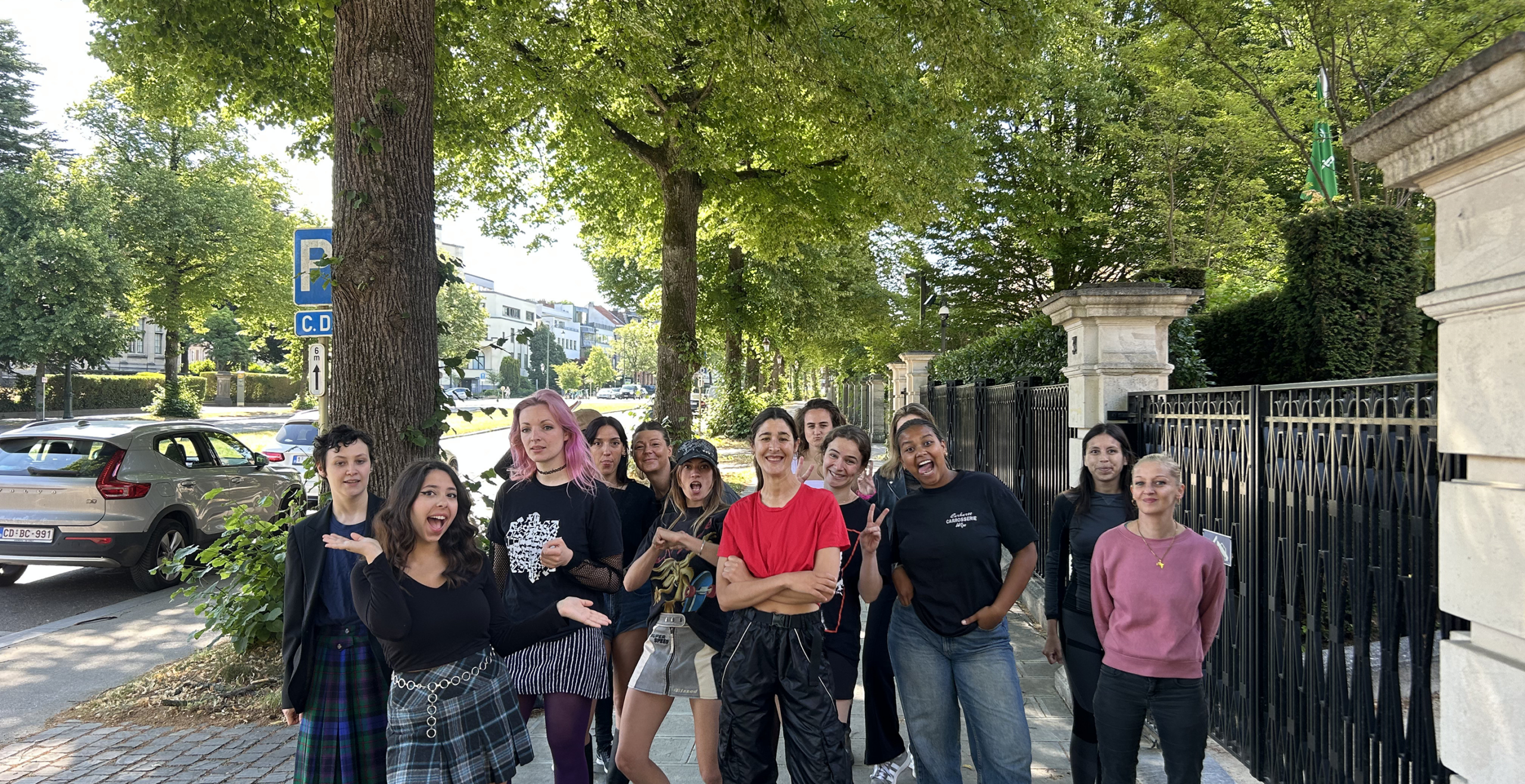 Équipe de l'association Basta posant dans une rue bordée d'arbres à Bruxelles
