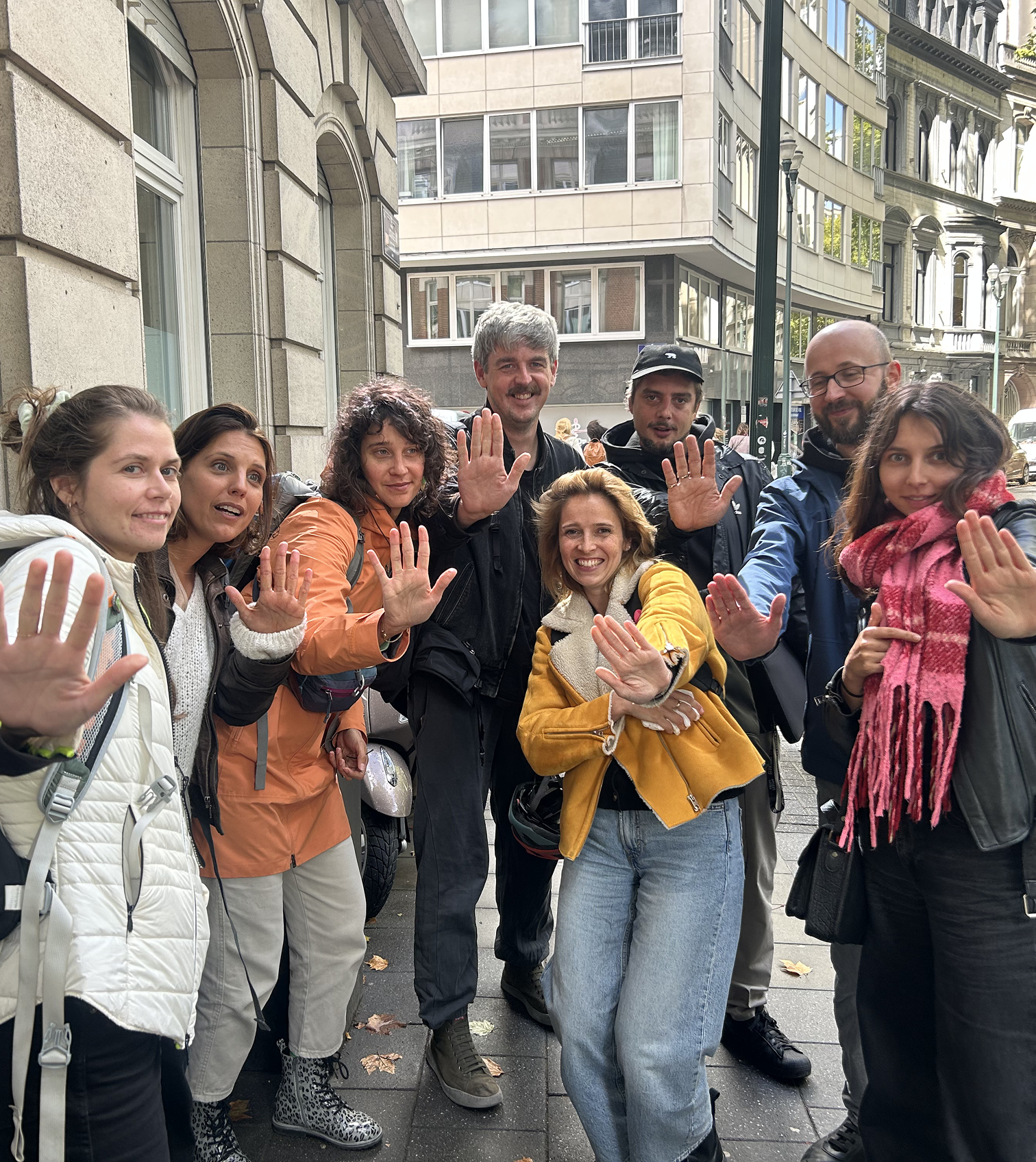 Groupe de personnes faisant le geste de la main levée symbole de Basta dans une rue de Bruxelles